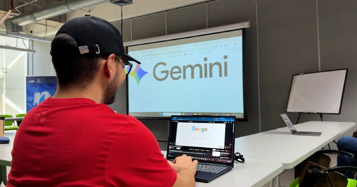 Formación gratuita en IA Colombia: aprende Gemini en un entorno práctico Estudiante trabajando en laptop durante una formación gratuita en IA Colombia con Gemini en un aula moderna