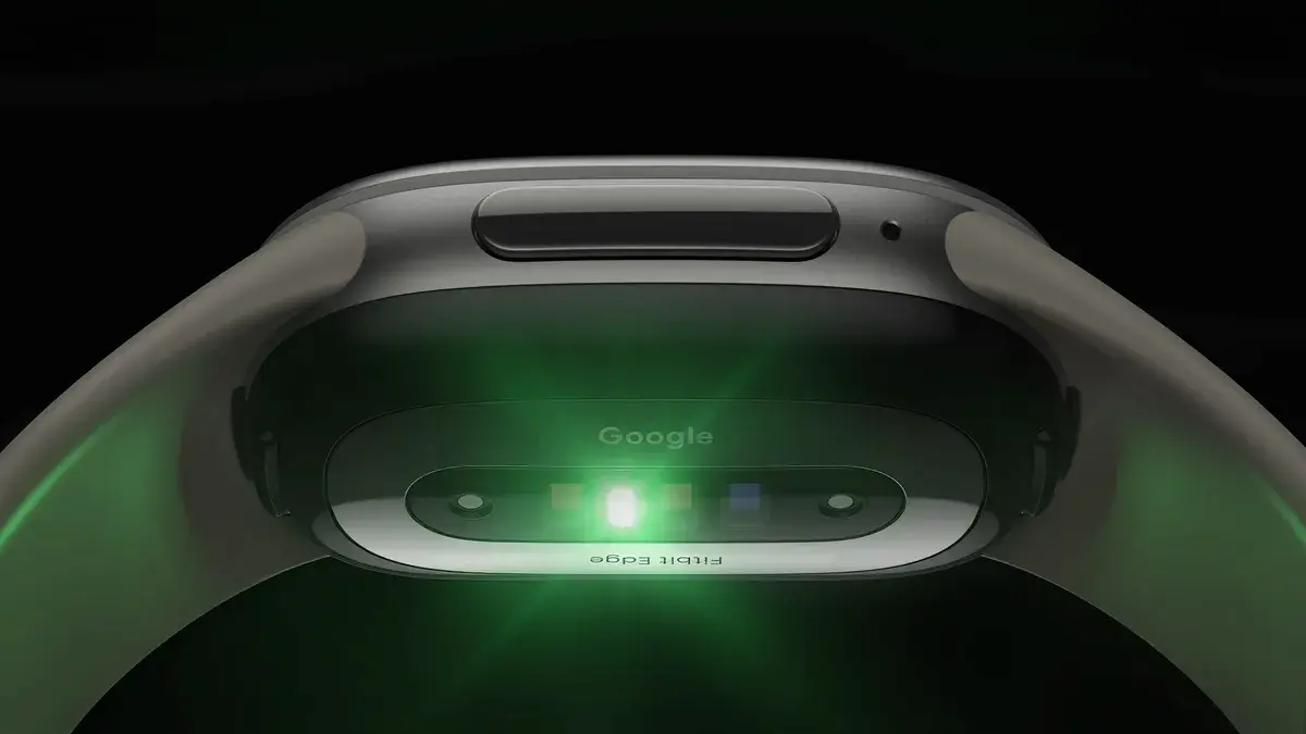 Google Fitbit Edge: vista de un dispositivo tecnológico de Google con sensores ópticos y luz verde.